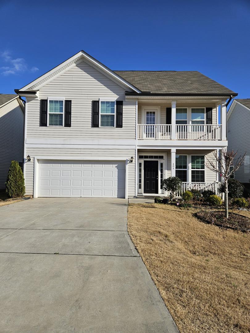 a front view of a house with yard and parking