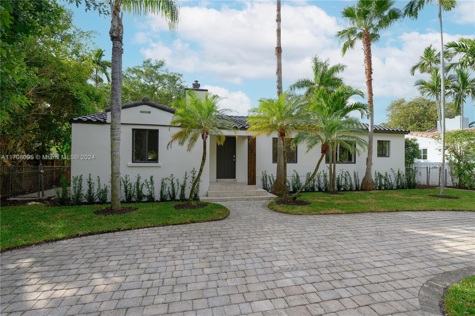 a front view of a house with a yard and potted plants