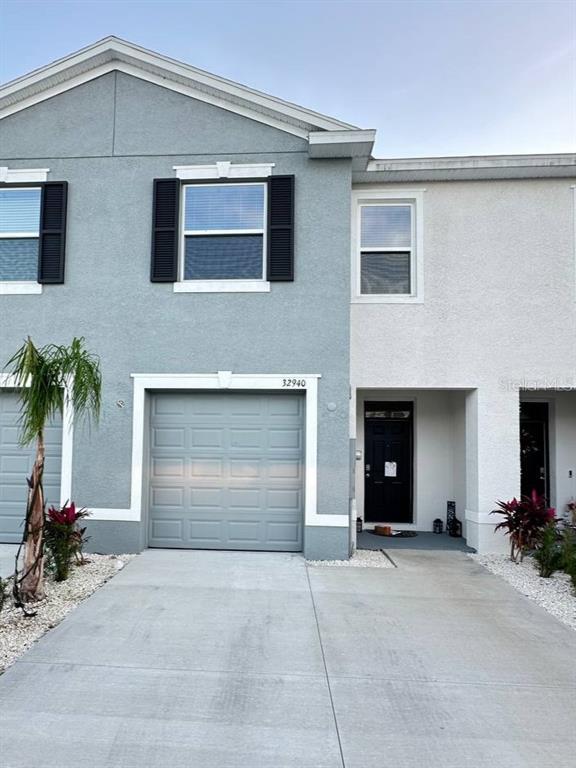 a front view of a house with a yard and a garage