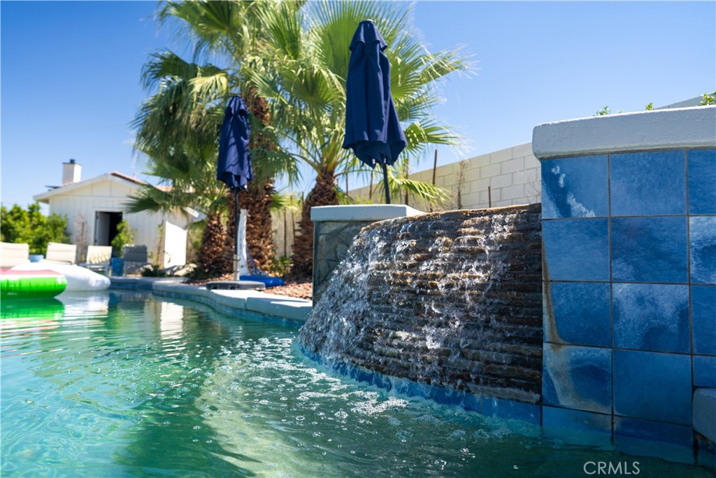 a view of swimming pool with a table and chairs under an umbrella