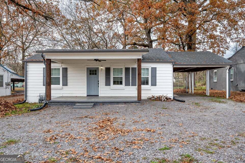 a front view of a house with a tree