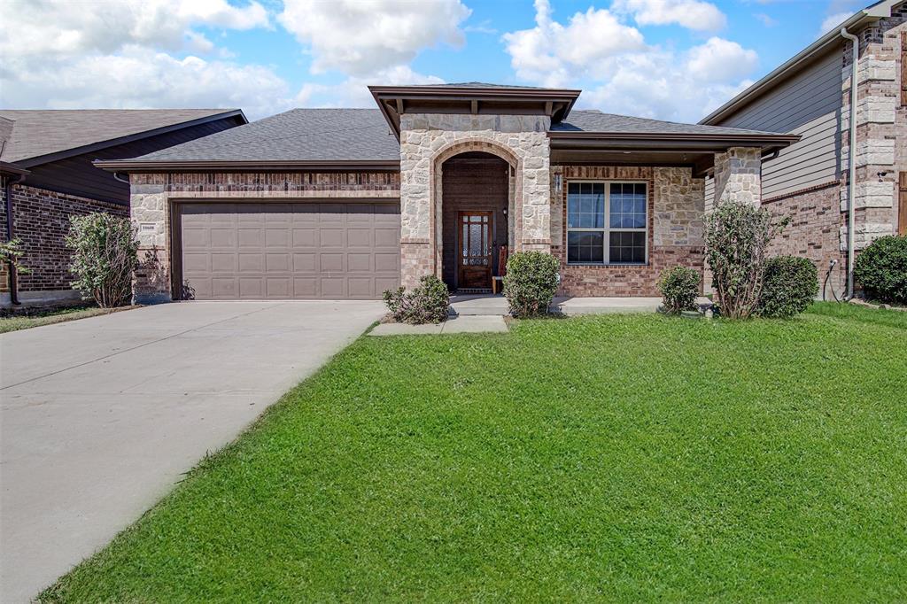 a front view of a house with a garden and yard