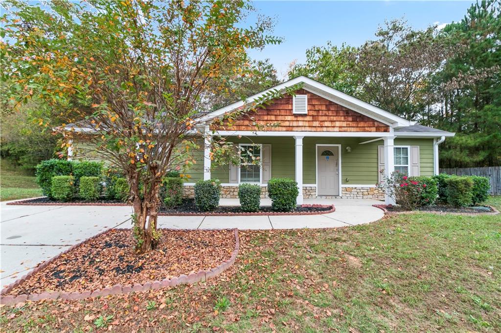 a front view of a house with a yard and potted plants