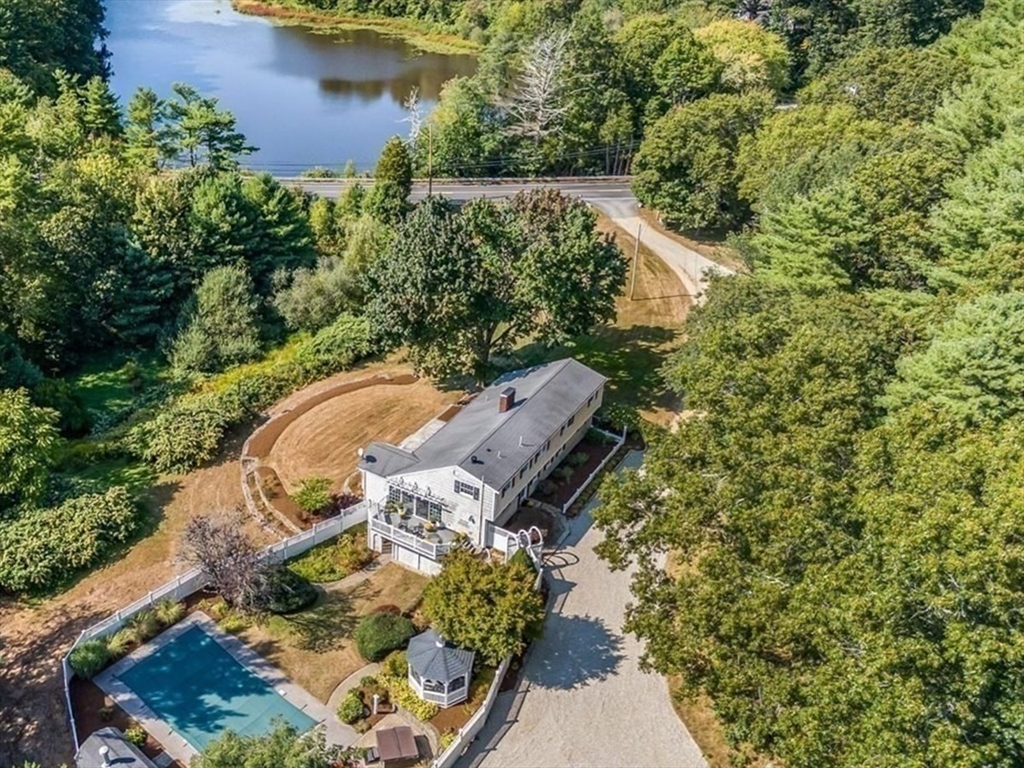 an aerial view of a house with a yard lake and outdoor seating