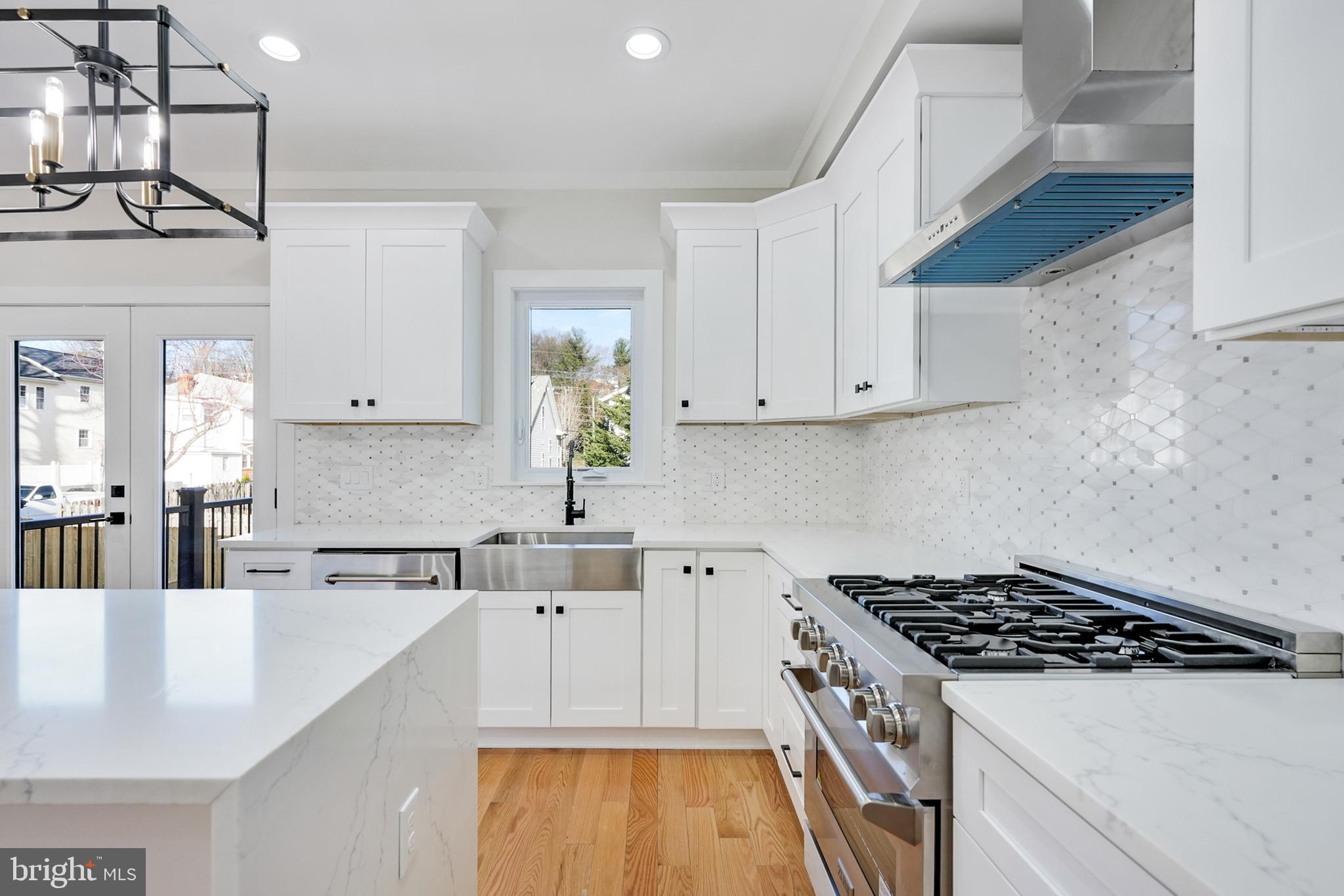 a kitchen with stainless steel appliances a sink a stove and cabinets