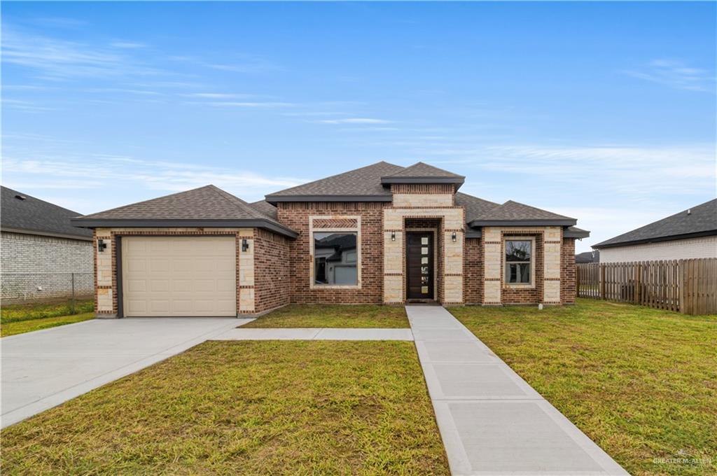 Prairie-style house featuring a garage and a front lawn