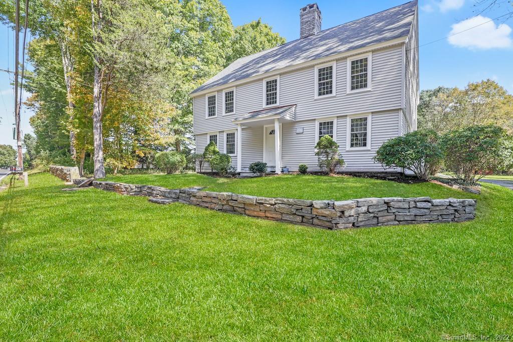 a front view of a house with a garden and trees