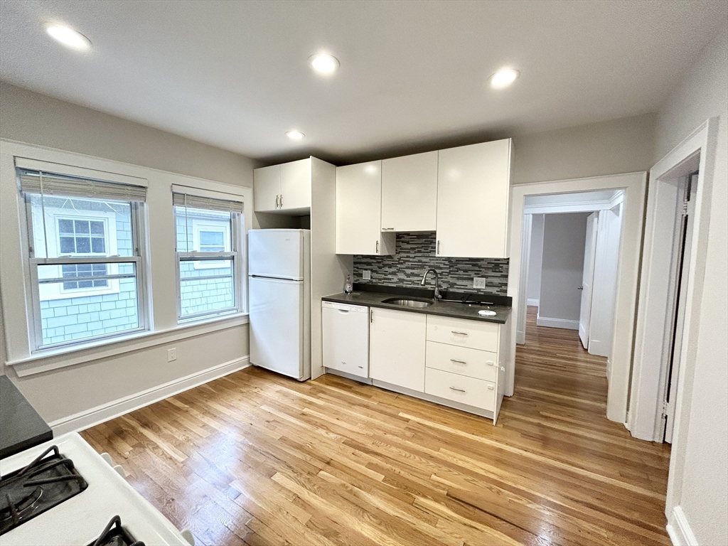 a kitchen with granite countertop white cabinets and white appliances