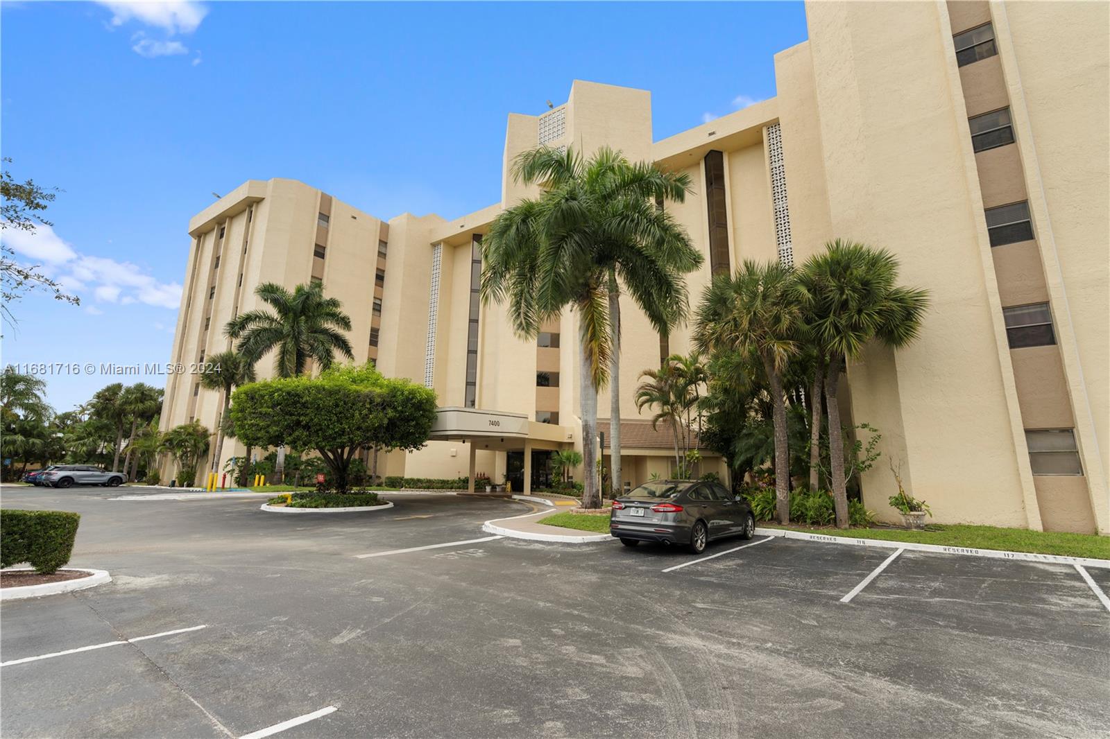 a car parked in front of a building with palm trees