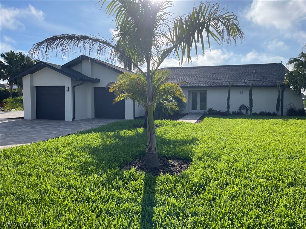 a view of a house with a yard and garage