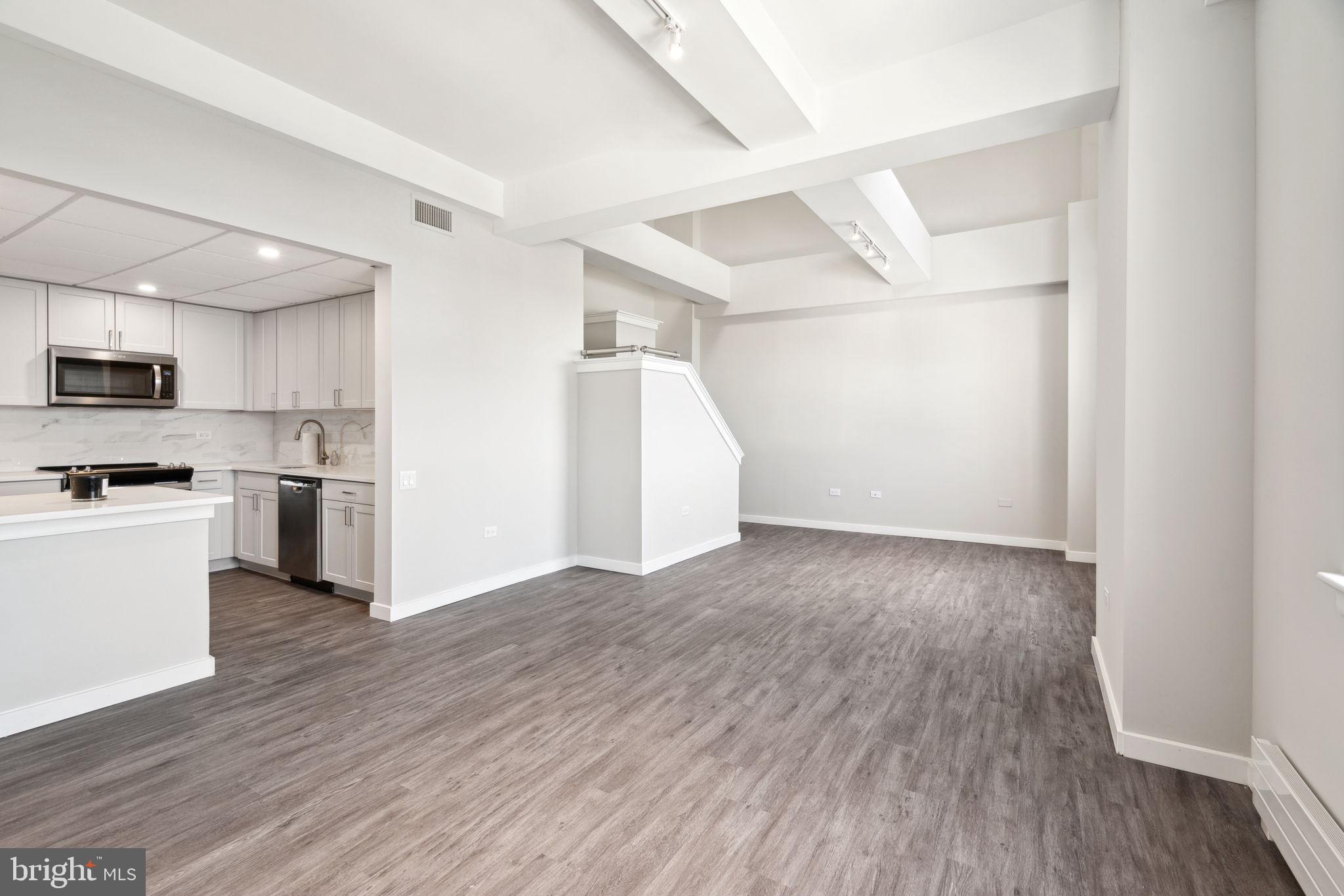 a view of kitchen with wooden floor and electronic appliances