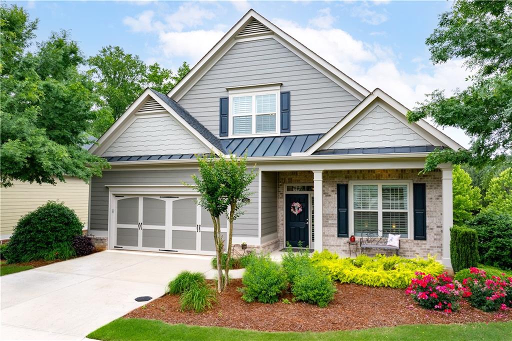 a front view of a house with a yard and potted plants