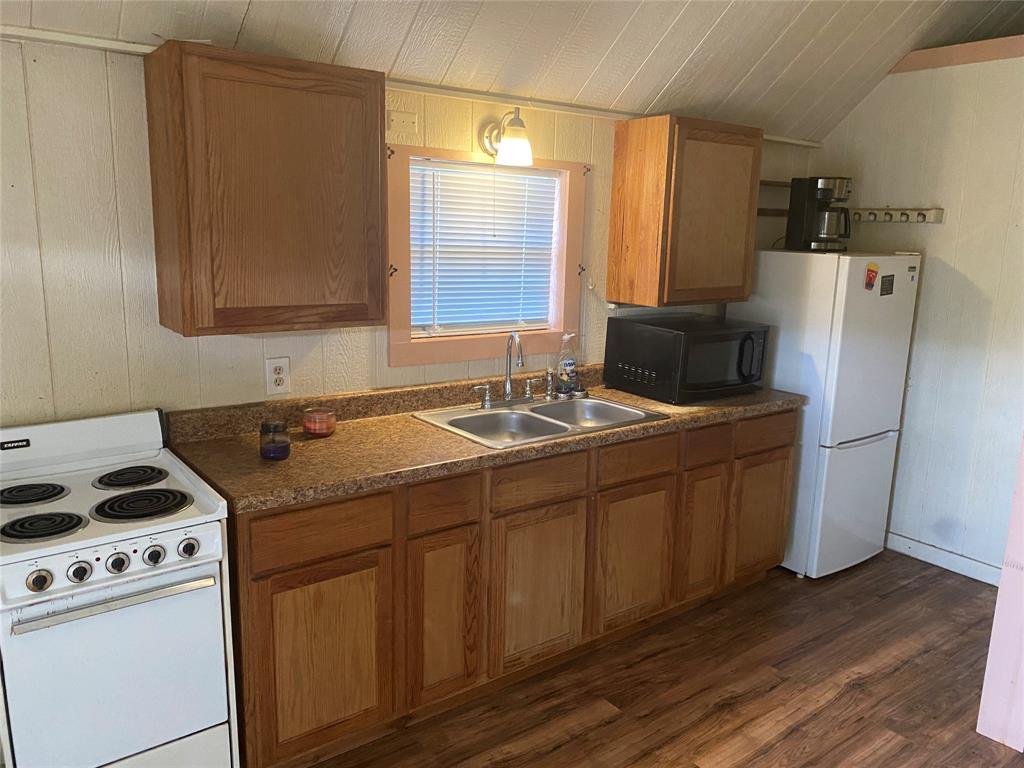 a kitchen with a sink a refrigerator and cabinets