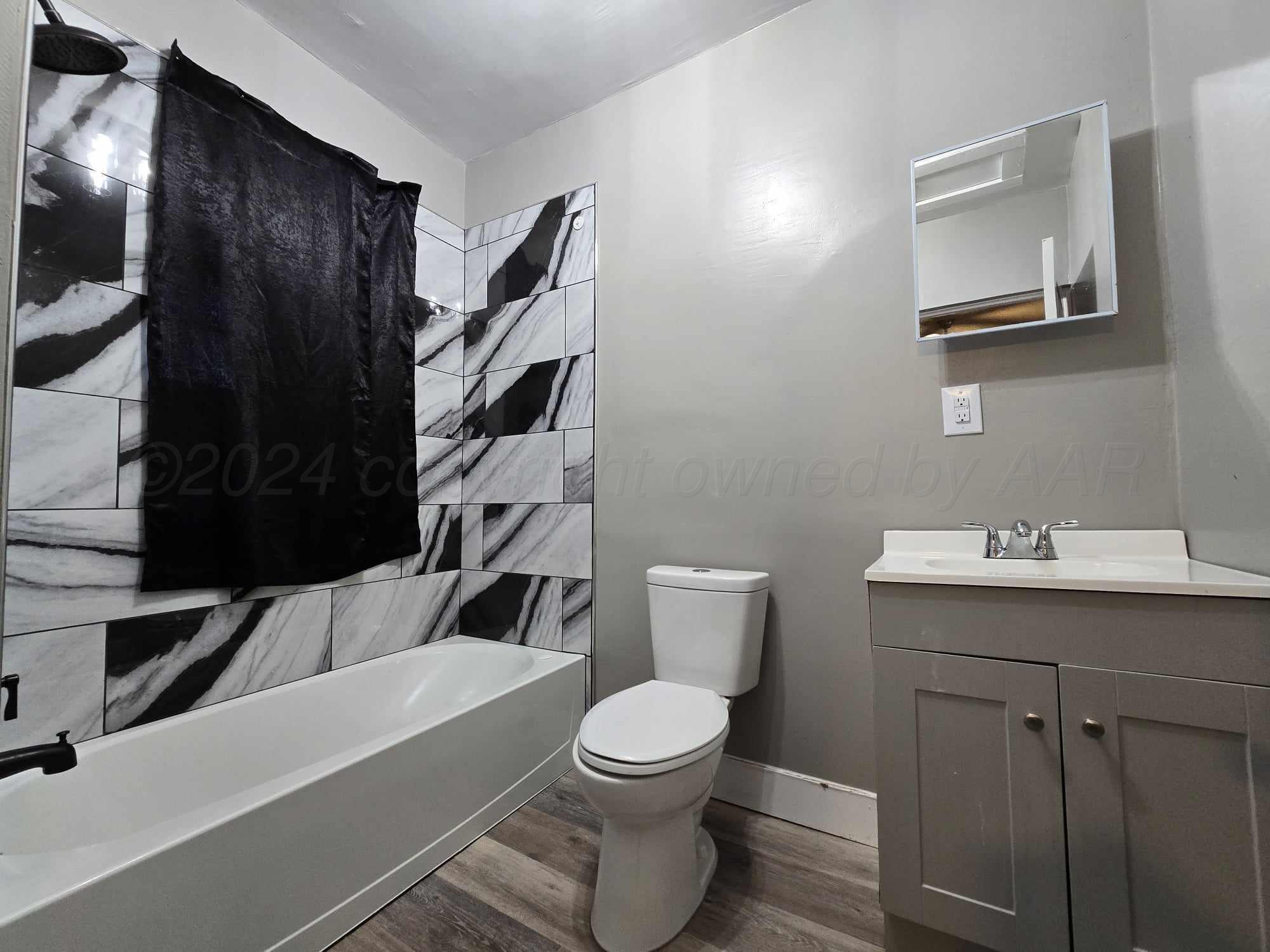 a bathroom with a toilet a sink and mirror