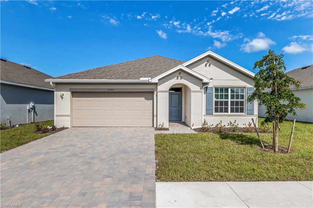 Ranch-style house with a garage and a front lawn