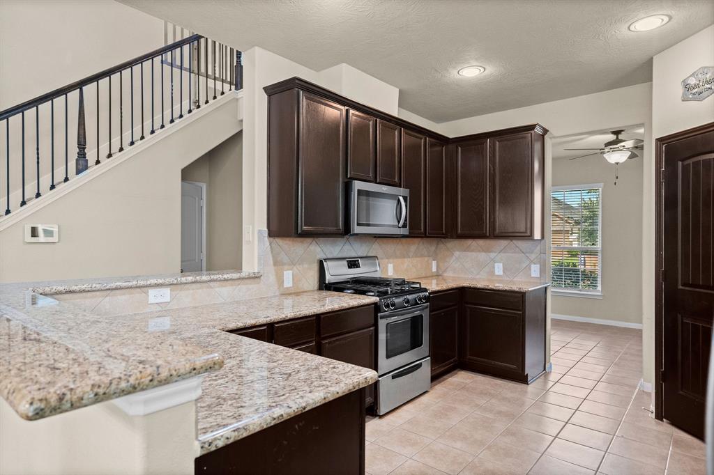 a kitchen with stainless steel appliances granite countertop a sink and a stove