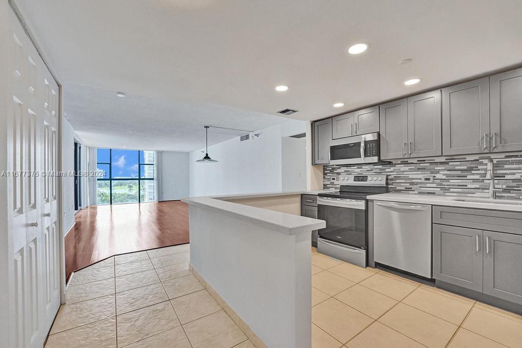 a kitchen with stainless steel appliances a refrigerator sink and cabinets