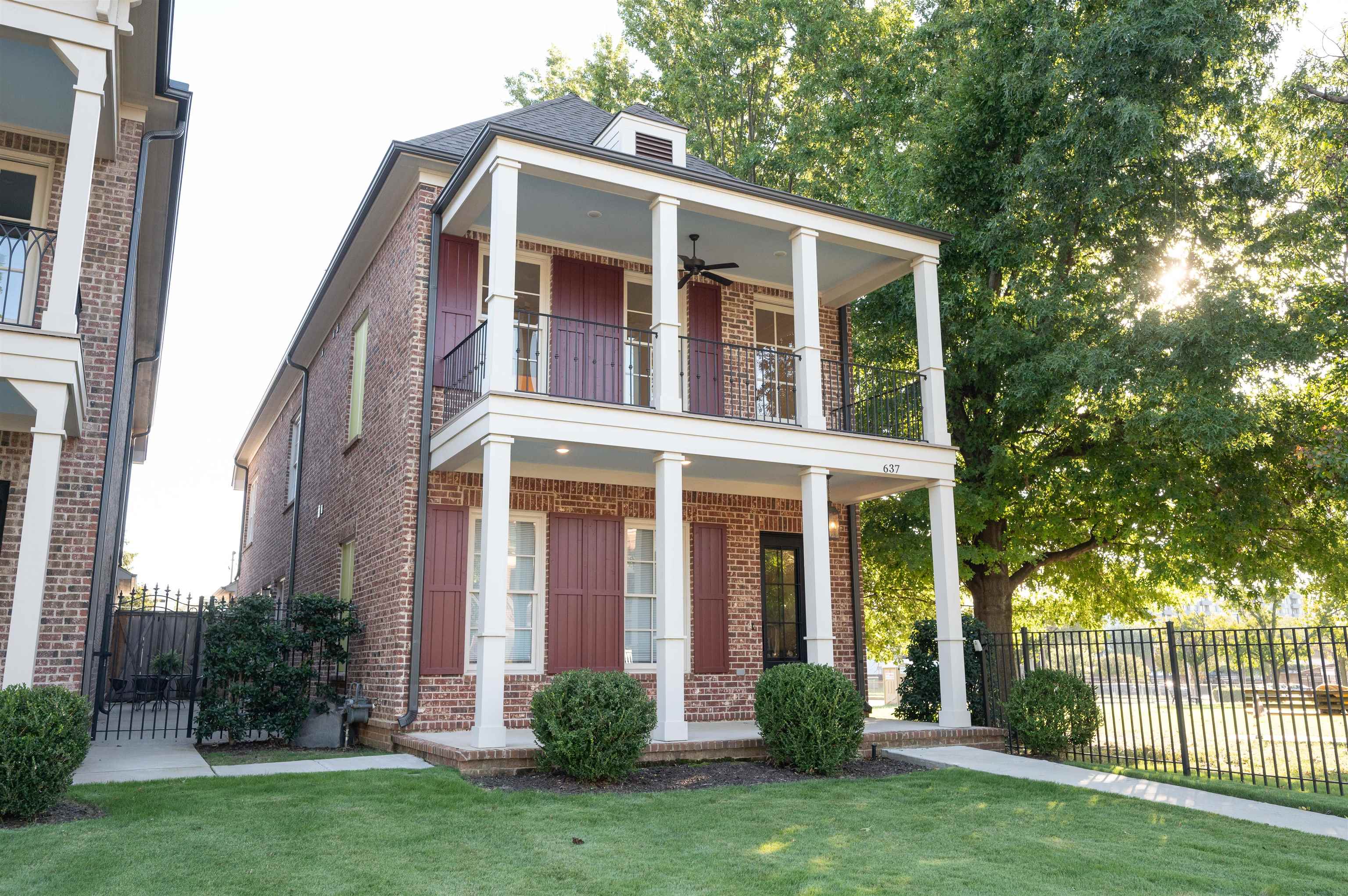 Neoclassical / greek revival house featuring a balcony, covered porch, a front yard, and ceiling fan