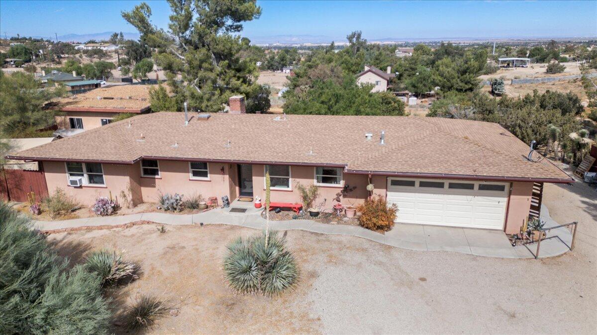 an aerial view of a house with yard and seating space