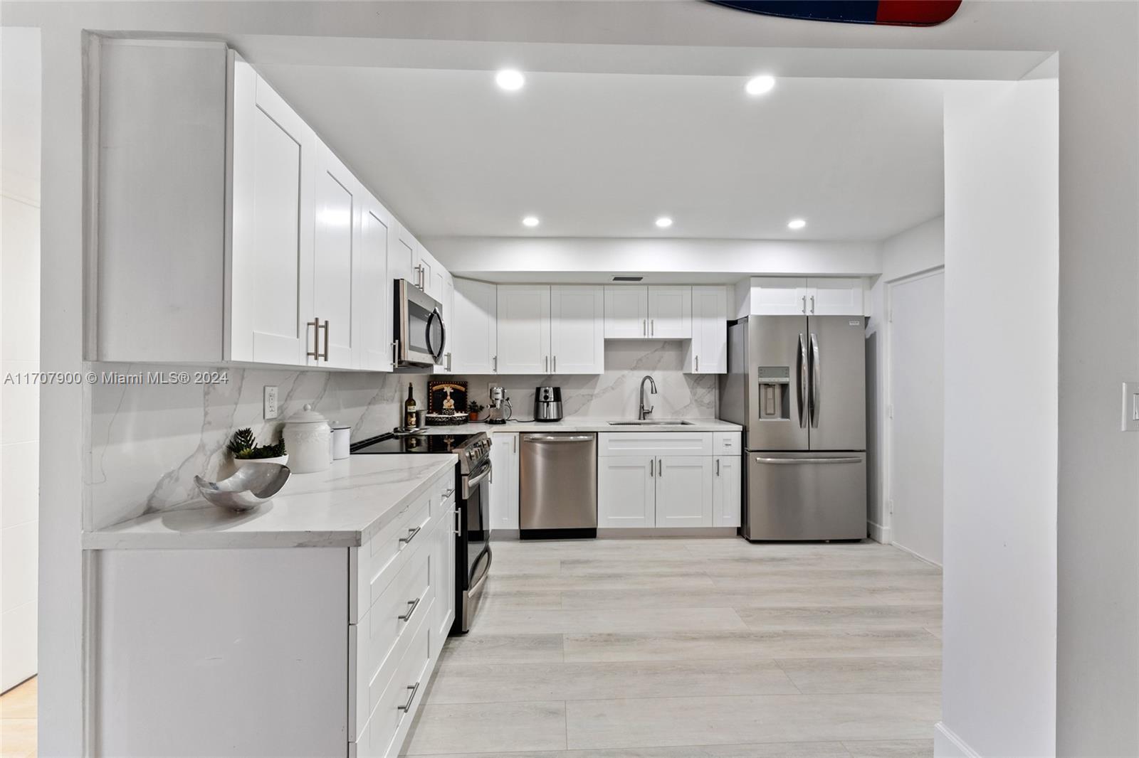 a kitchen with a sink a refrigerator and cabinets