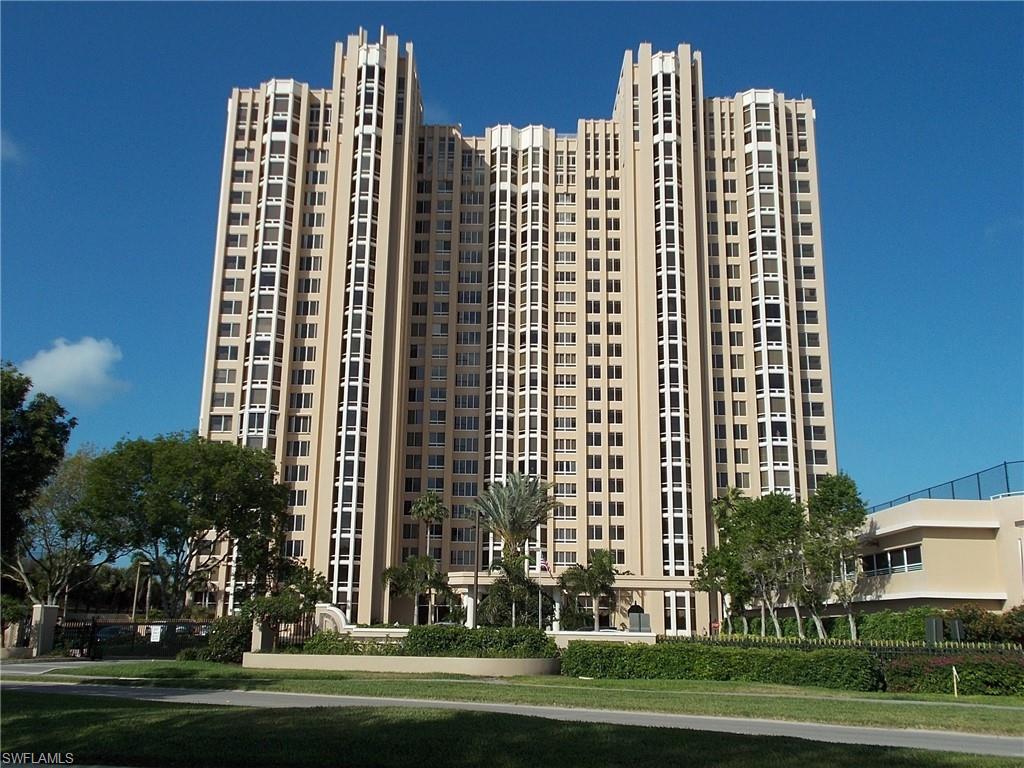 a front view of multi story residential apartment building with a yard