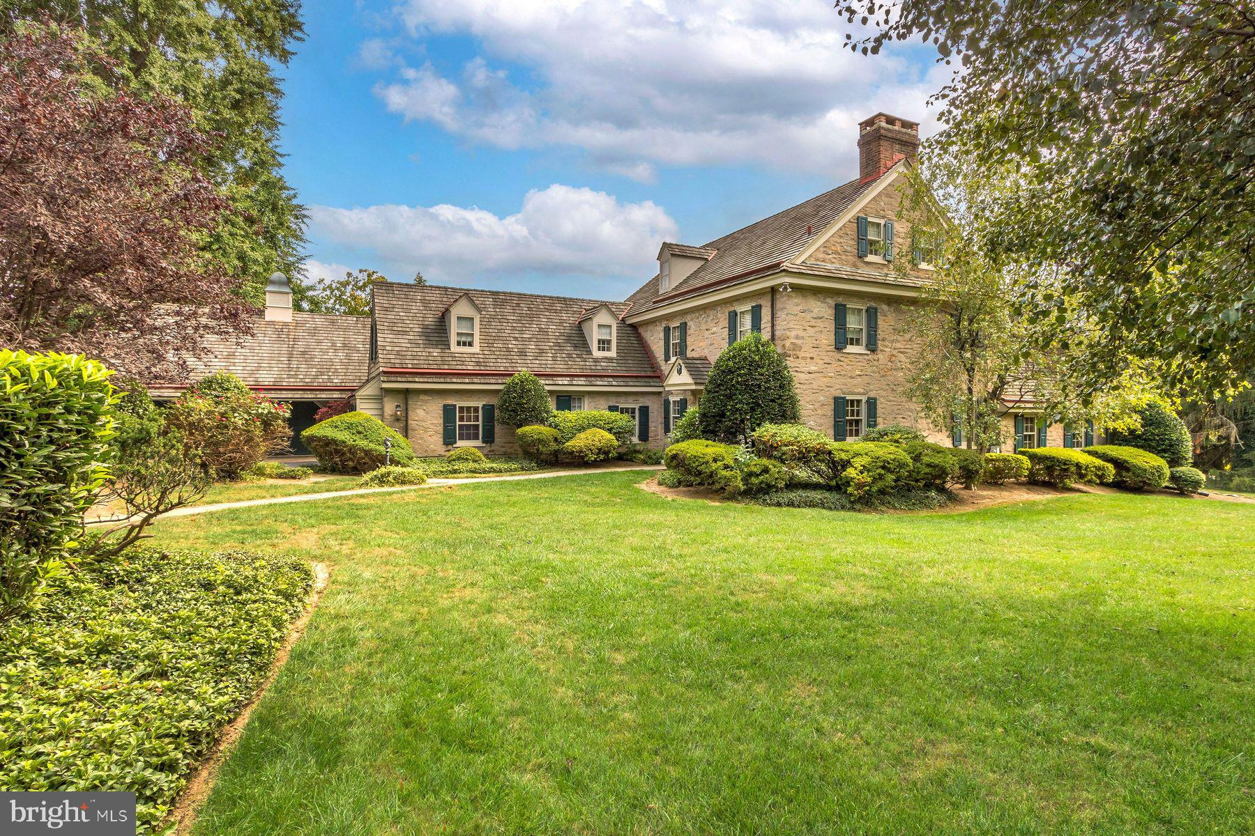 a view of a house with a big yard plants and large trees