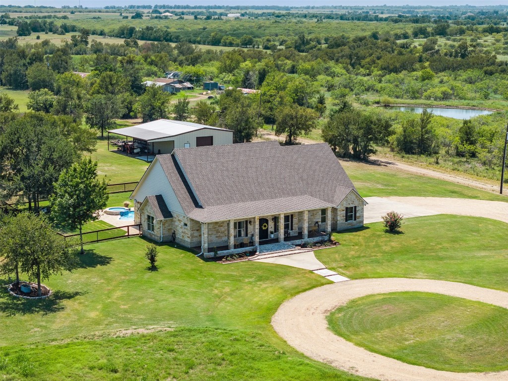 an aerial view of residential houses with outdoor space and trees