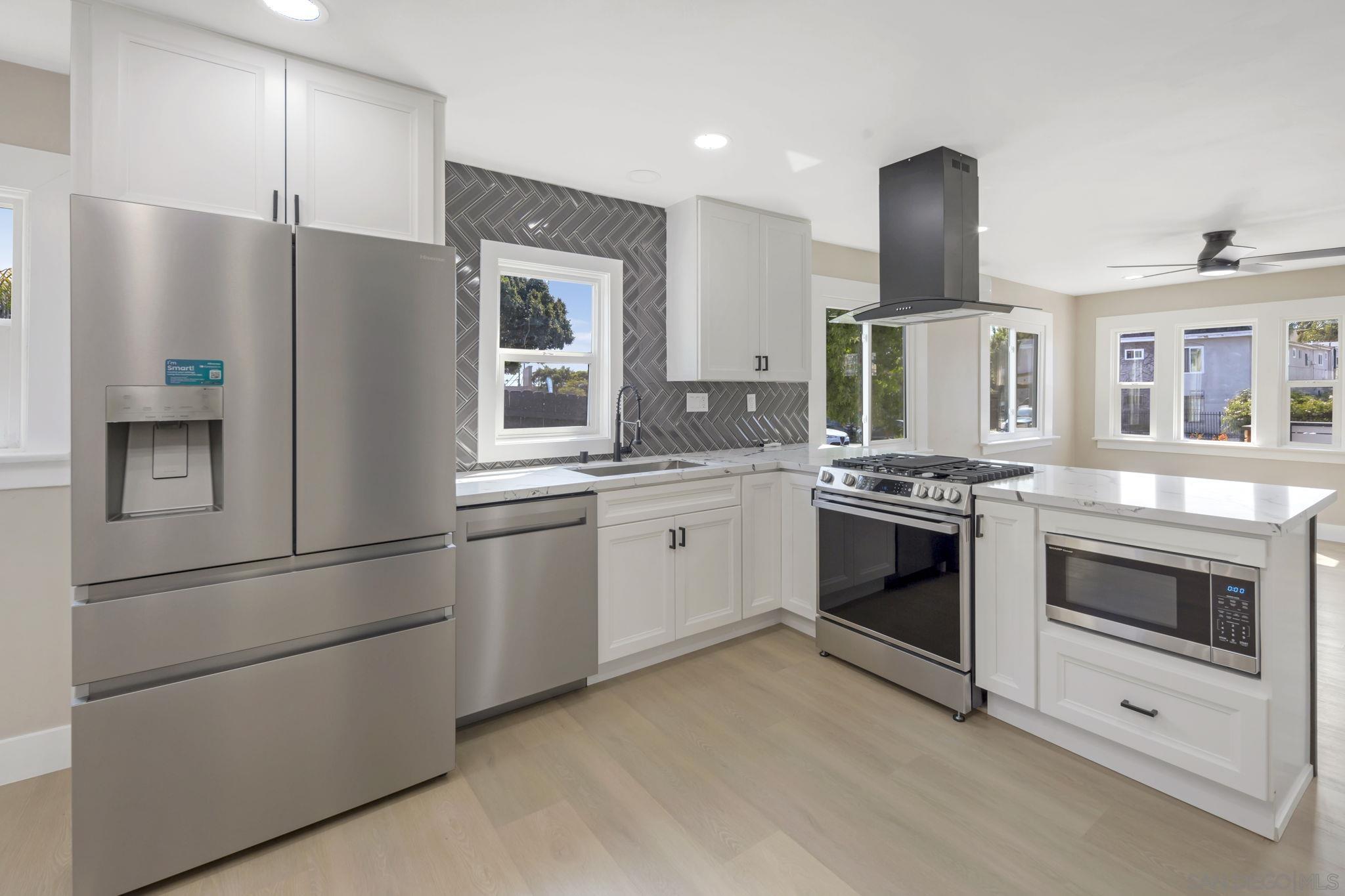 a kitchen with stainless steel appliances a refrigerator sink and stove