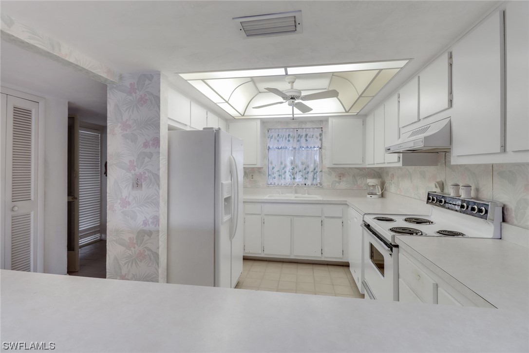 a kitchen with stainless steel appliances a white stove top oven and cabinets