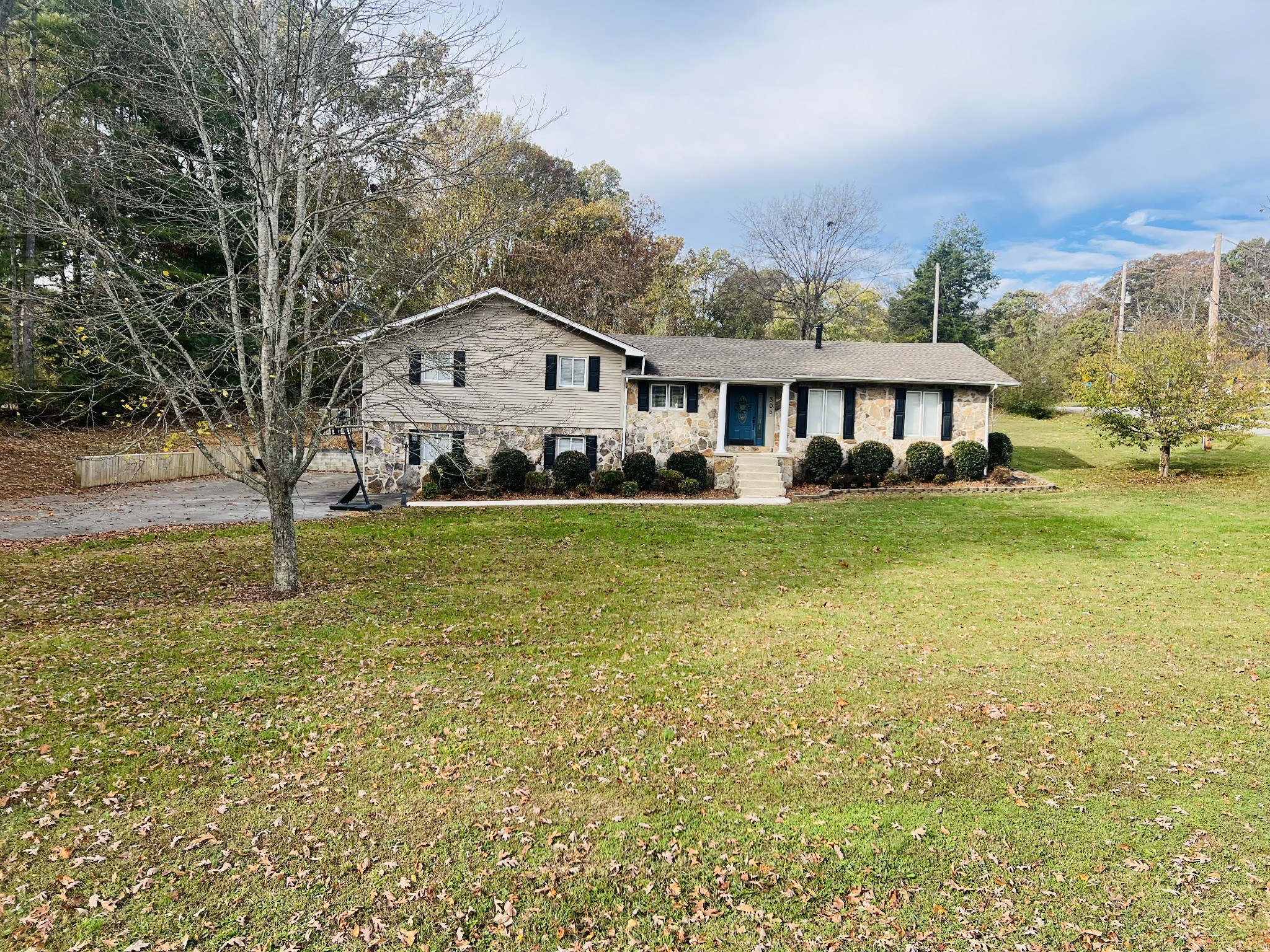 a view of a house with a big yard and large trees