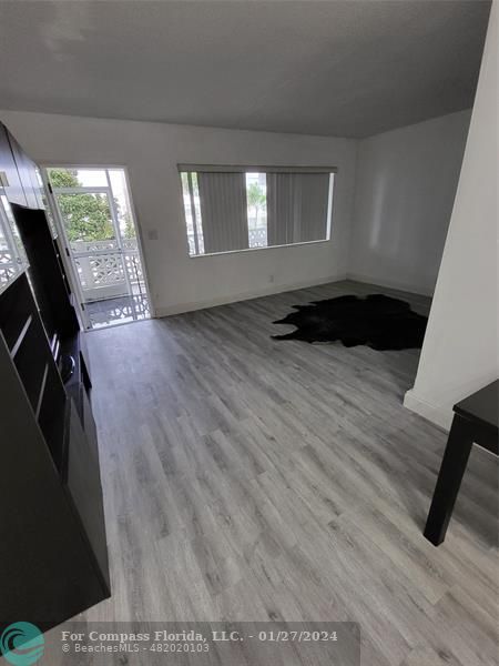 a kitchen with stainless steel appliances wooden floor and a table