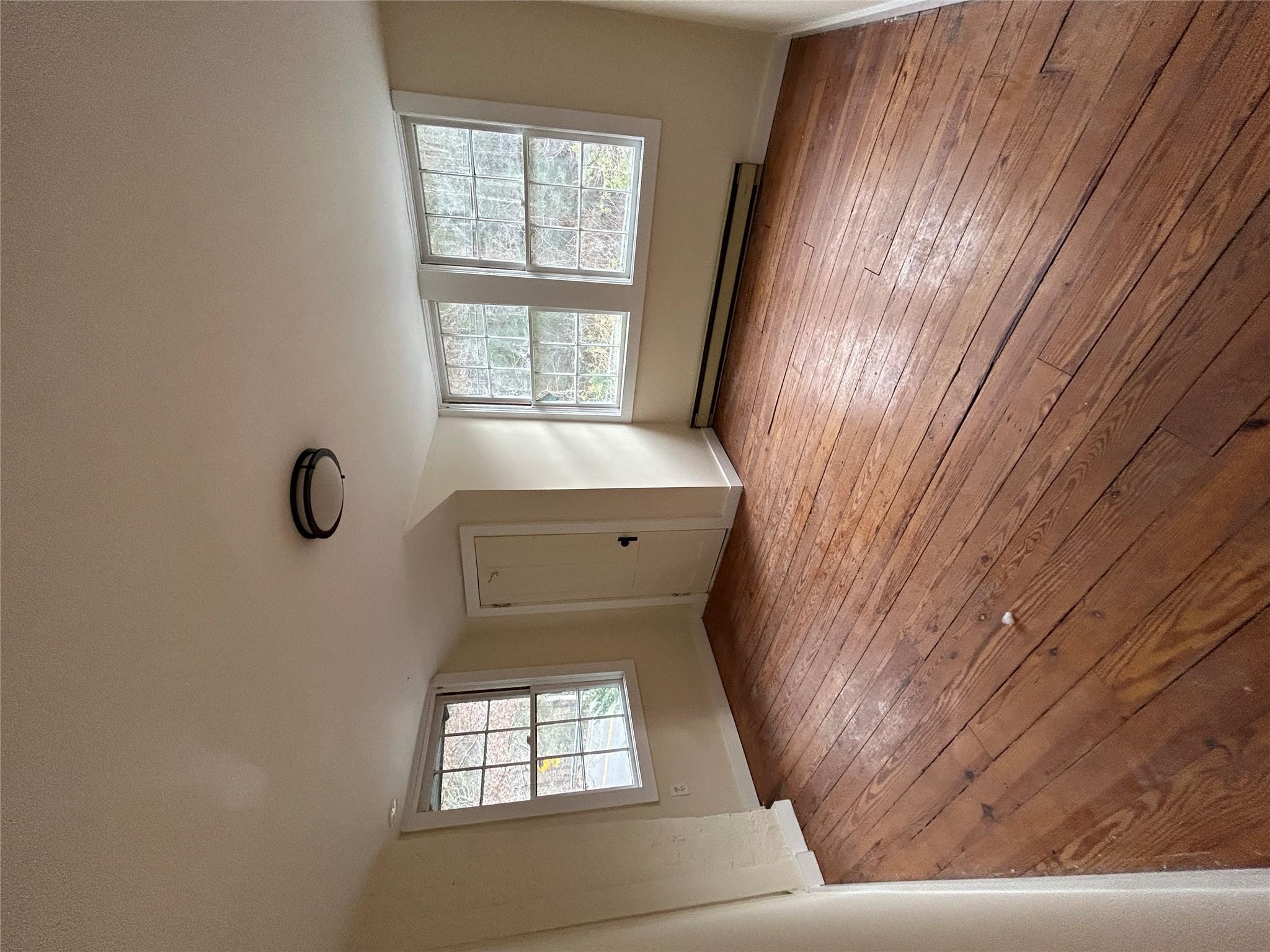 Additional living space featuring plenty of natural light, light hardwood / wood-style flooring, and a baseboard heating unit