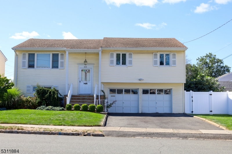 a large house with a large parking space and plants in the back