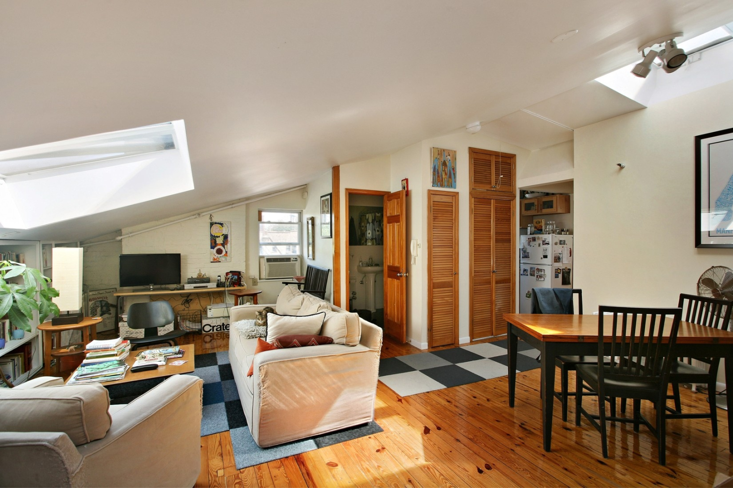 a living room with furniture wooden floor and a flat screen tv