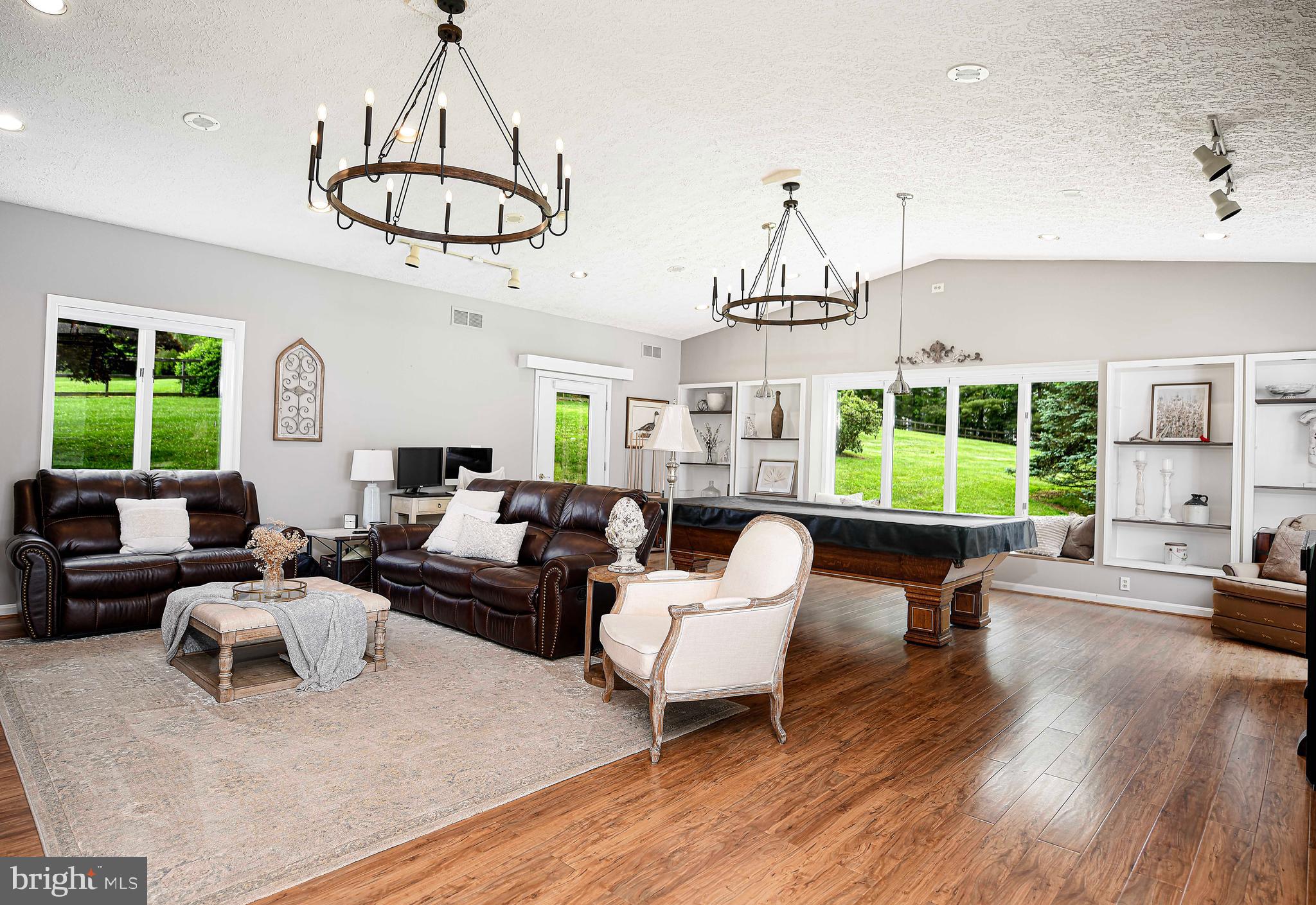 a living room with furniture chandelier and a window