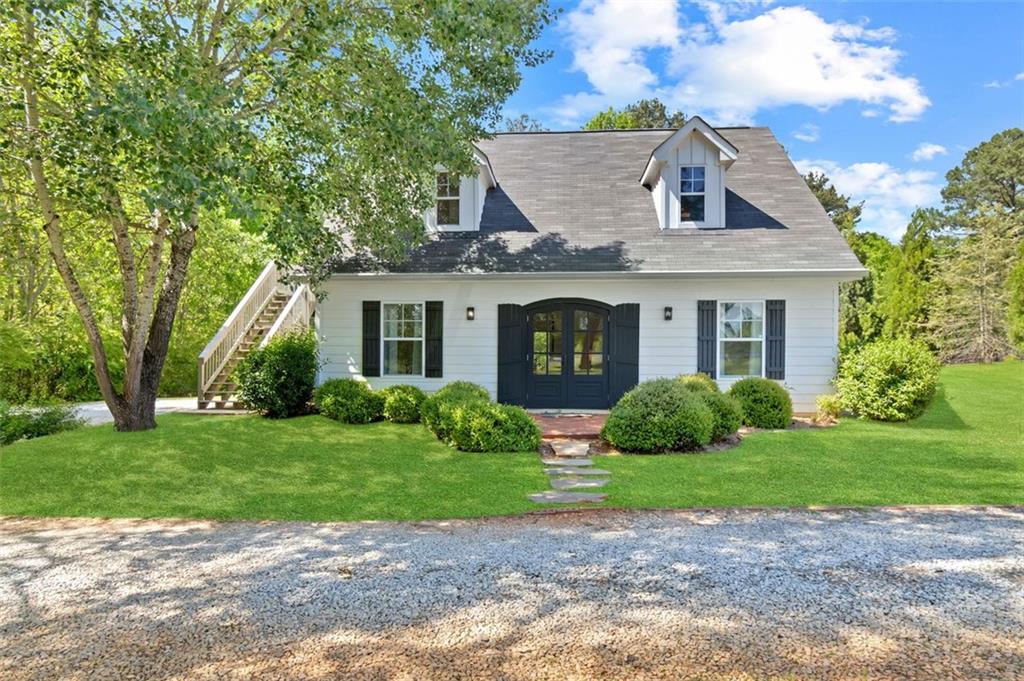 a front view of a house with a garden and yard