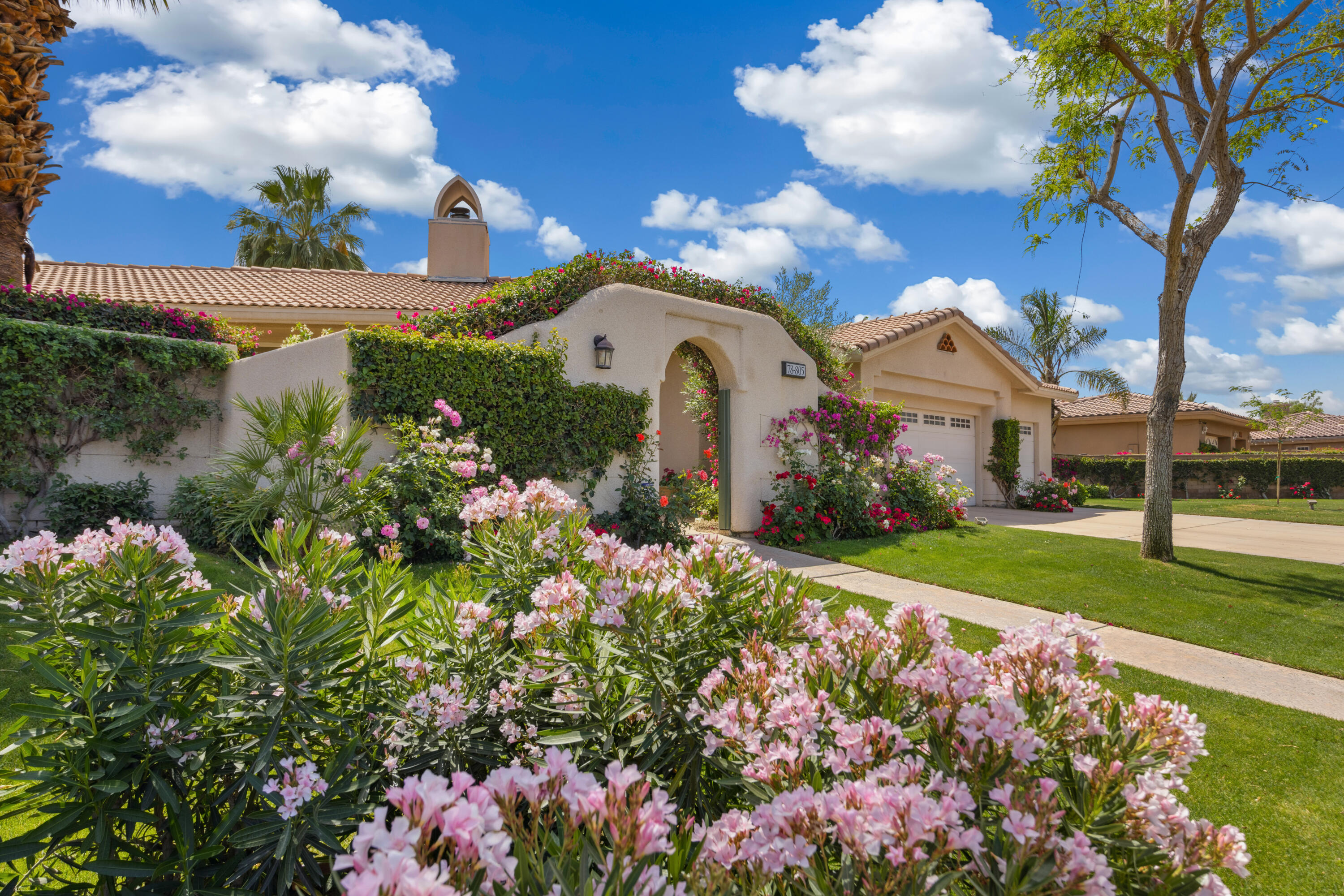 a front view of a house with a yard and fountain in middle