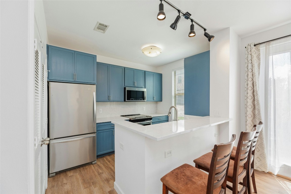 a white refrigerator freezer sitting in a kitchen with stainless steel appliances granite countertop furniture and a refrigerator