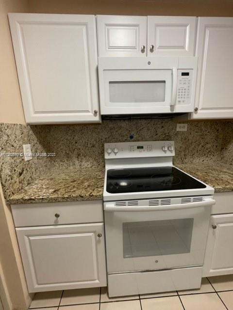 a stove top oven sitting inside of a kitchen