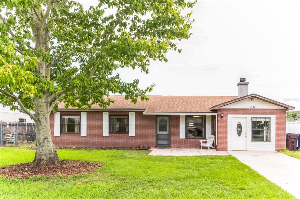 a front view of a house with a garden and yard