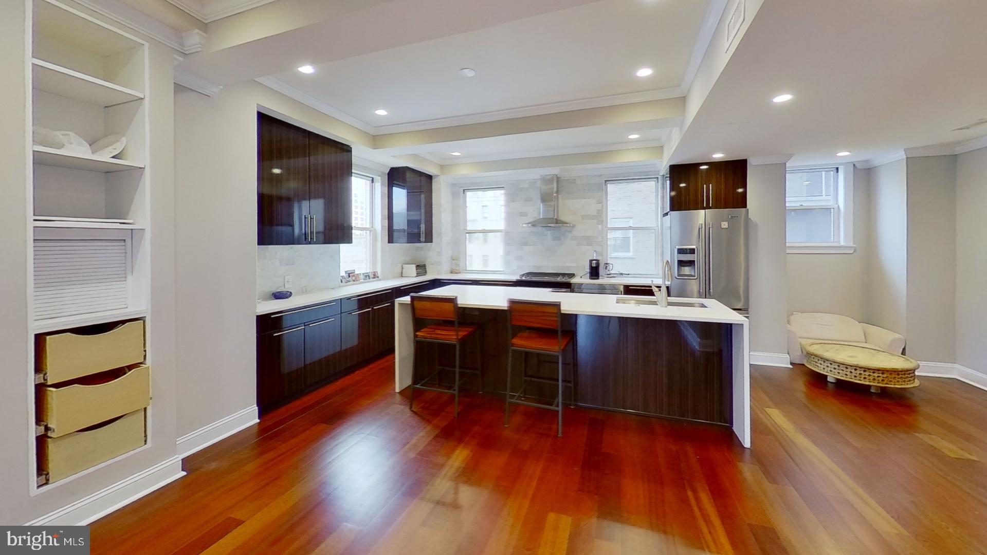 a kitchen with stainless steel appliances granite countertop a sink a stove and a wooden floors