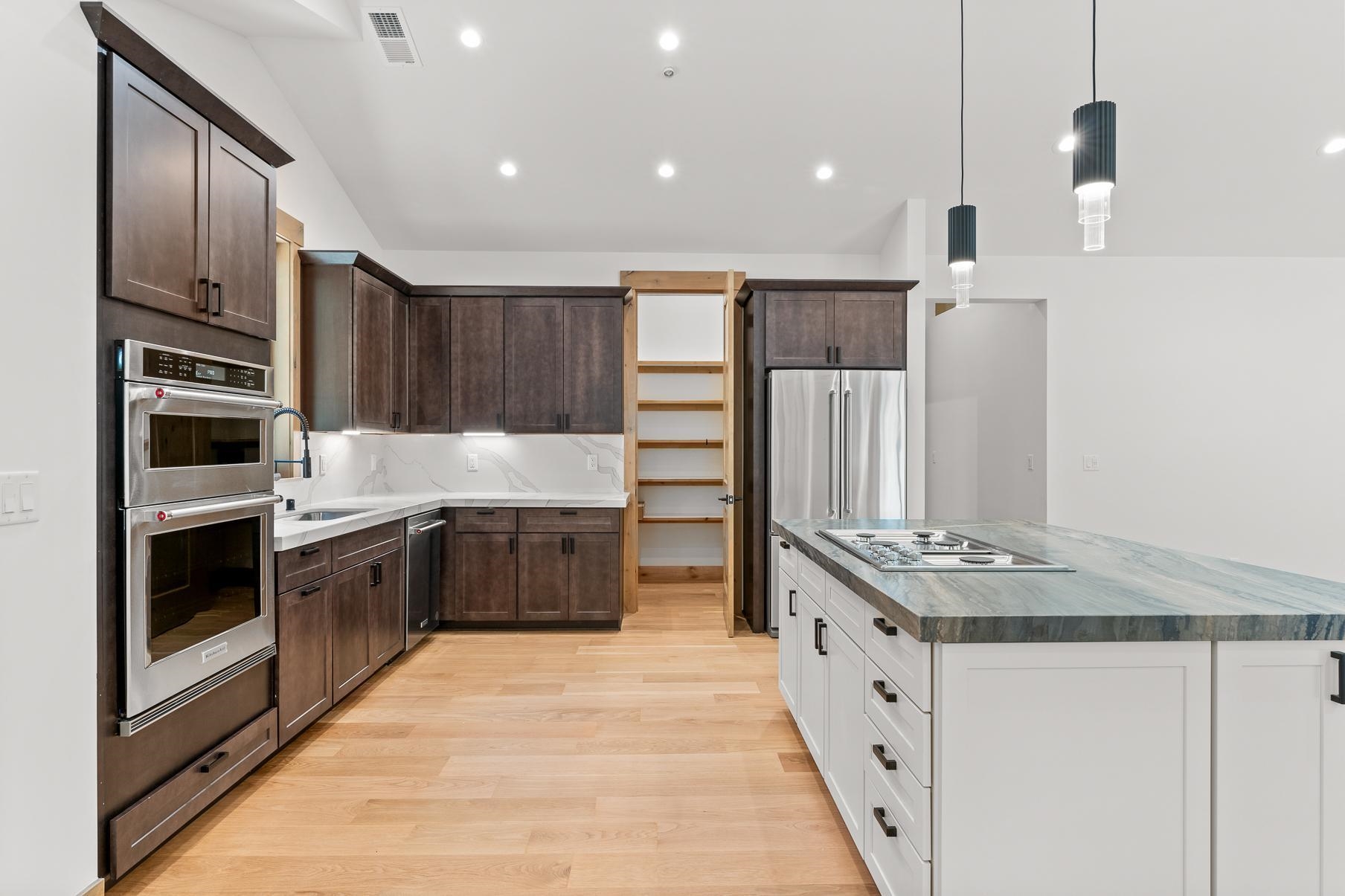 a large kitchen with stainless steel appliances granite countertop a stove and a refrigerator