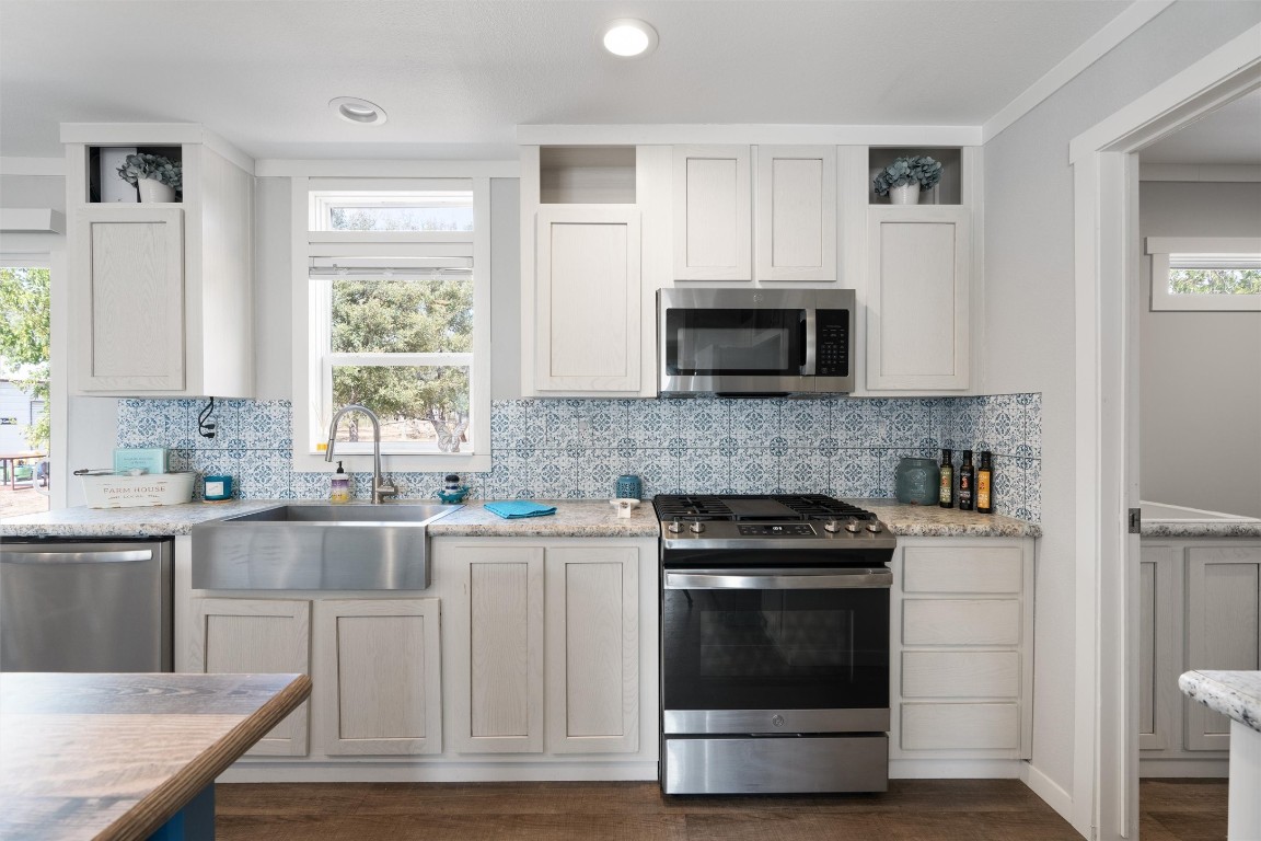 a kitchen with cabinets stainless steel appliances and a window