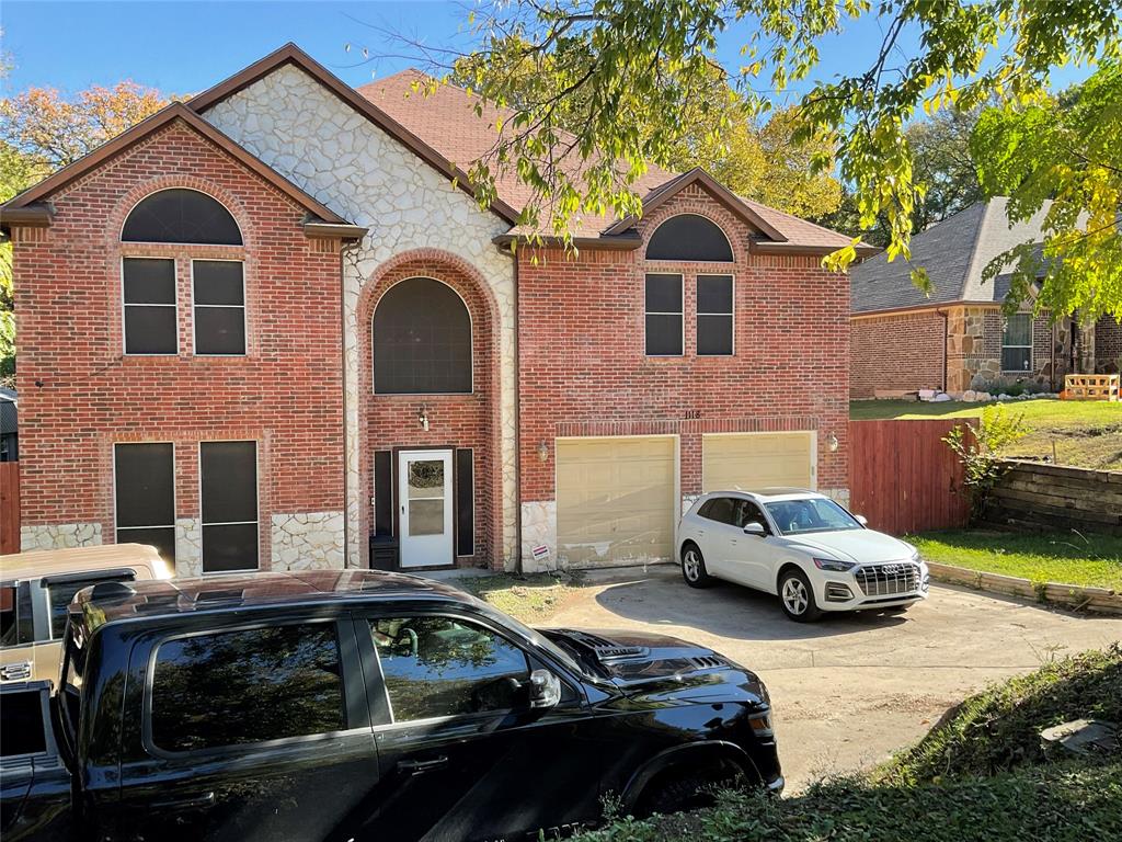 a front view of a house with cars parked