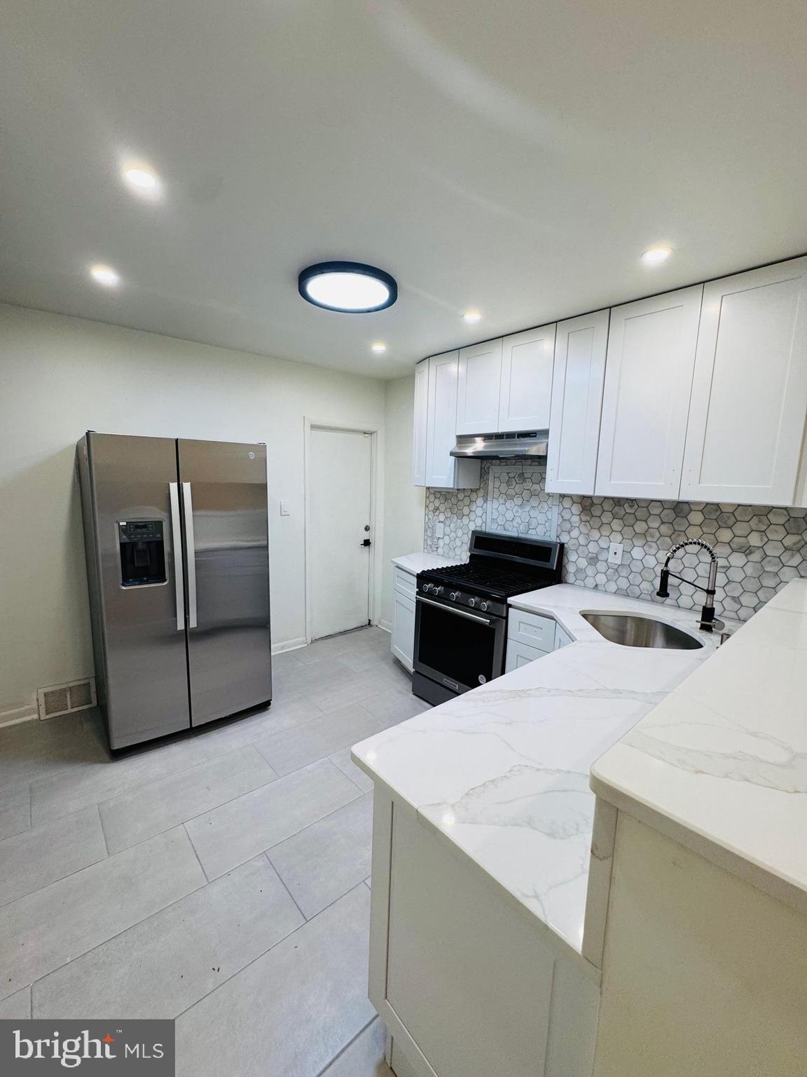 a kitchen with stainless steel appliances granite countertop a sink and a stove