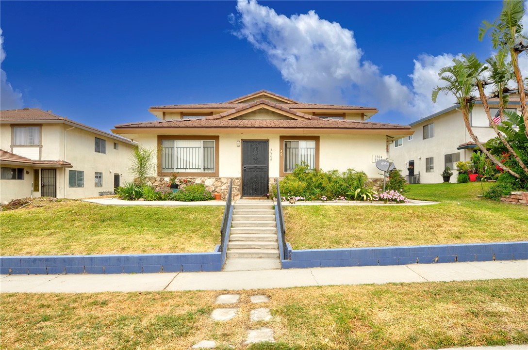 a view of a large house with a big yard and potted plants