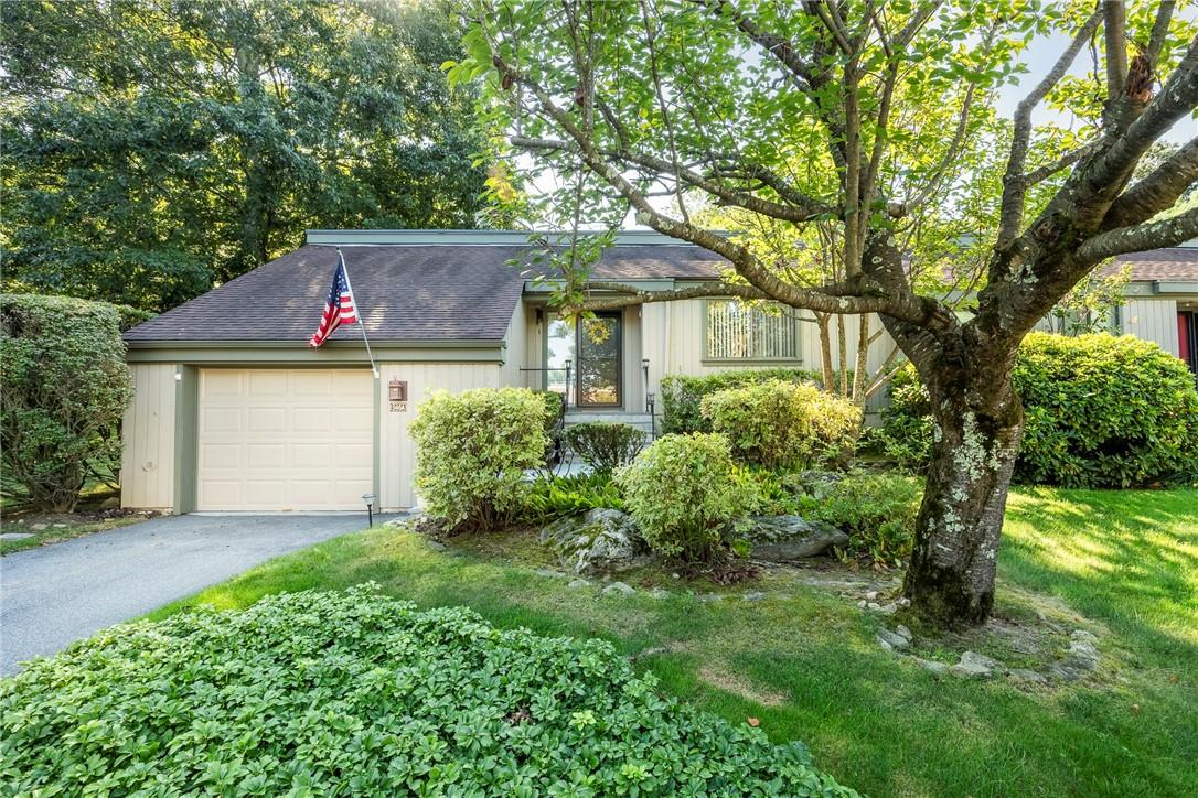 a front view of house with yard and trees around