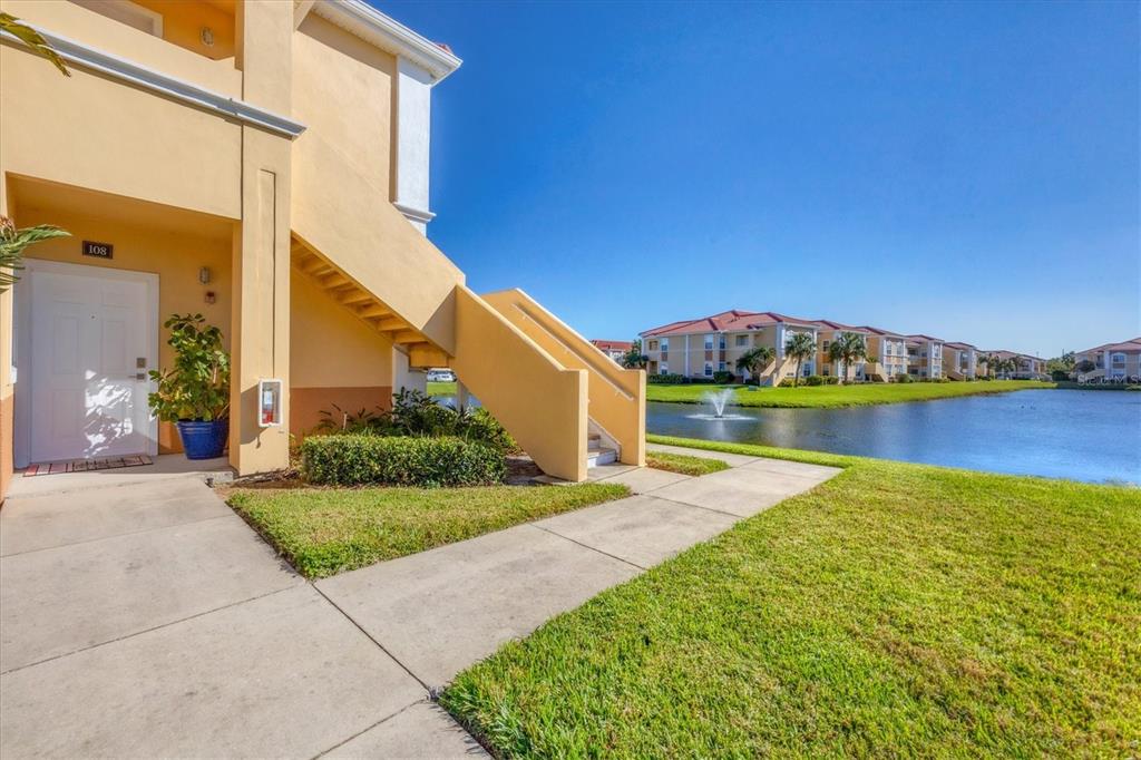 a view of a house with a yard and lake view