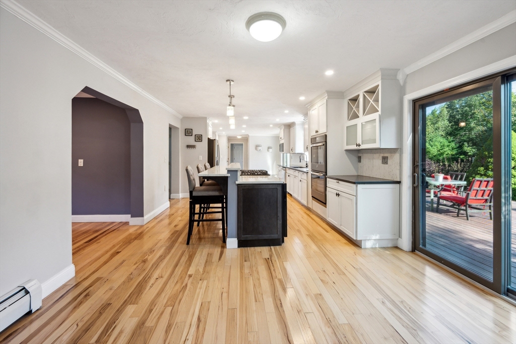 a kitchen with stainless steel appliances kitchen island granite countertop a refrigerator and a wooden floors