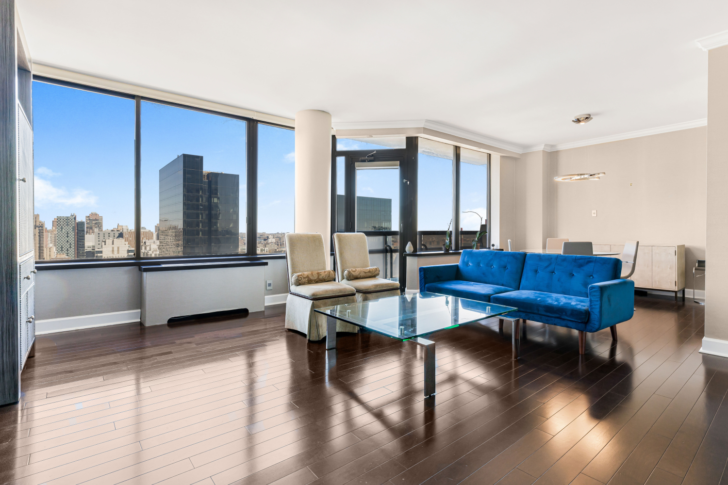 a living room with couches chairs and a coffee table with wooden floor